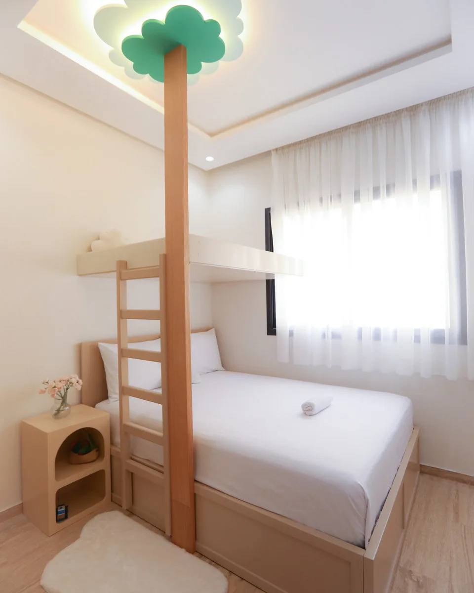 La chambre d'enfants du Doux Nuage : lit en hauteur avec échelle et arbre lumineux au plafond.