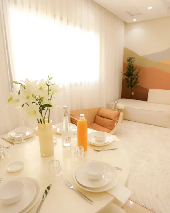 Photo jointe à l'avis : une table dressée dans un salon clair.