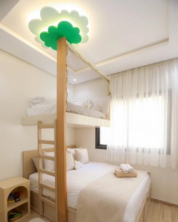 Photo jointe à l'avis : une chambre d'enfants avec un lit en hauteur et un arbre au plafond.