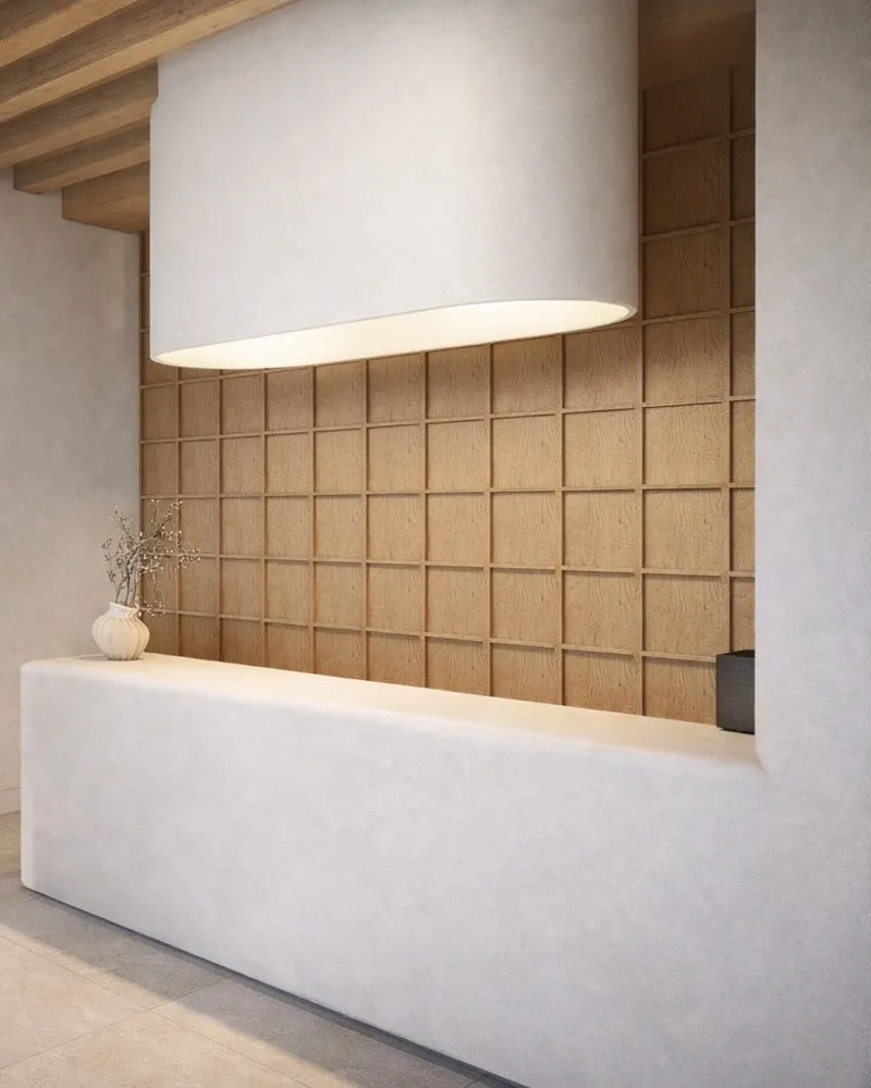 La réception de l'hôtel : comptoir blanc, mur en panneaux de bois et poutres au plafond.