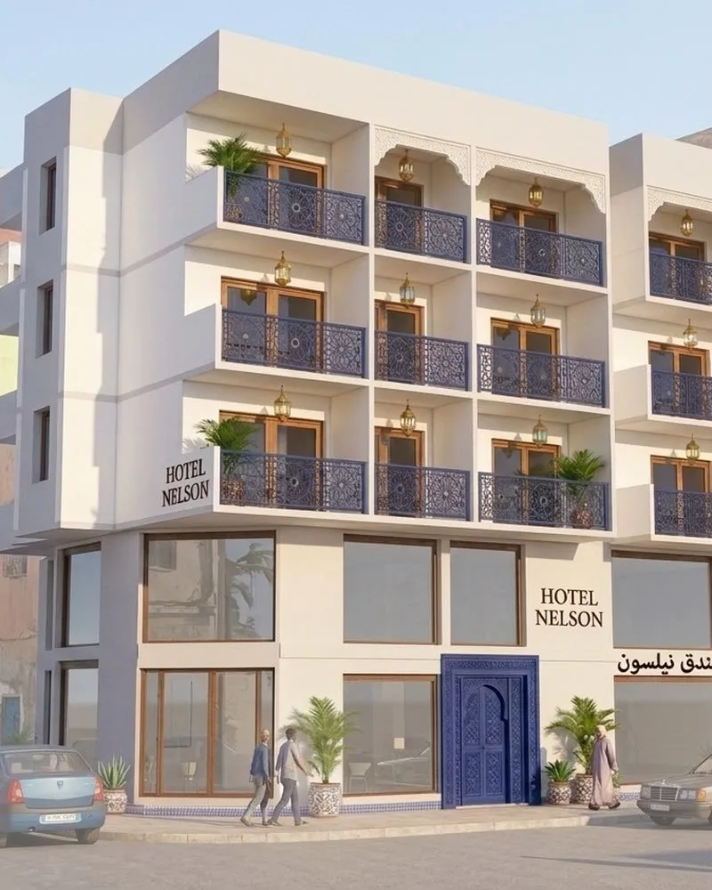 La façade de l'hôtel, blanche avec des balcons bleus, vue depuis la rue.